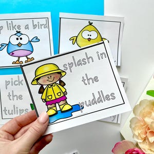 May include: Four printable cards with black outlines and colorful illustrations. The cards feature the phrases "flap like a bird", "pick the tulips", "splash in the puddles", and a chick with a yellow body and black eyes.