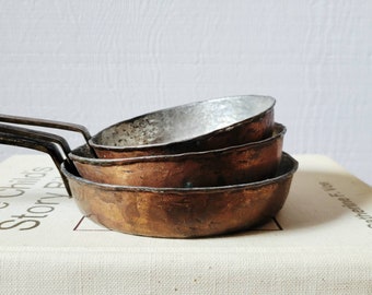 Set of three hand-forged copper frying pans.