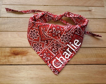 May include: Red bandana with a white paisley pattern and the name "Charlie" embroidered in white.