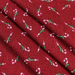 May include: Red fabric with a repeating pattern of white and red candy canes with green holly leaves.