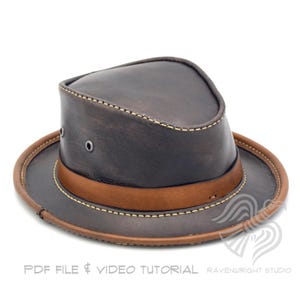 May include: A brown leather fedora hat with a light brown band and brim. The hat has a classic design with visible stitching and metal eyelets. The text "PDF FILE & VIDEO TUTORIAL" is at the bottom.
