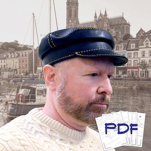 May include: A navy blue leather cap with yellow stitching. The cap has a flat top and a short brim. The image also shows a person wearing a cream-colored sweater and holding a stack of papers with the word "PDF" in blue.