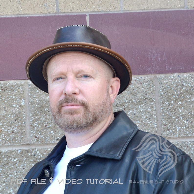 May include: A dark brown fedora-style hat with a light brown brim and stitching detail. The hat is worn by a person wearing a black leather jacket and a white shirt. The image includes text that reads "PDF FILE & VIDEO TUTORIAL" and "RAVENWRIGHT STUDIO".