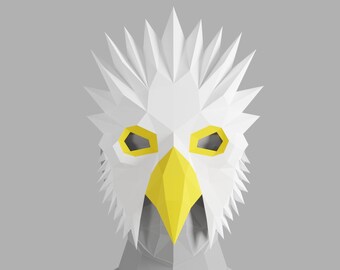 May include: A white origami mask with a yellow beak and eyes. The mask is in the shape of an eagle's head.