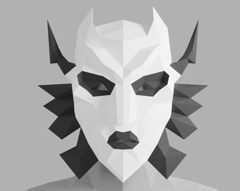 May include: A white paper mask with black geometric details, resembling a stylised face with sharp angles and a pointed chin. The mask has a triangular shape with two pointed ears on the sides.