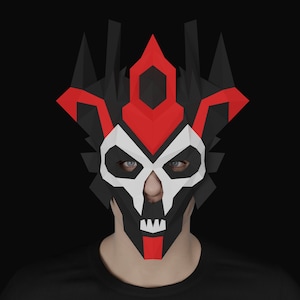 May include: A black and red papercraft mask with a skull design. The mask has a sharp, angular shape with a pointed crown and a white skull face with black eyes.