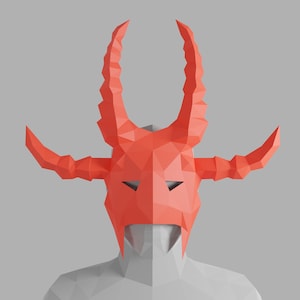 May include: A red origami mask with horns, resembling a devil or demon. The mask is made of paper and has a geometric design.