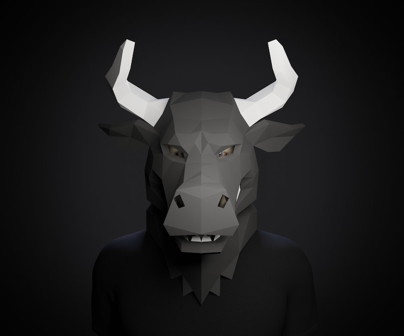May include: A black bull mask with white horns. The mask is made of paper and has a 3D design. The mask is worn by a person with a black shirt.