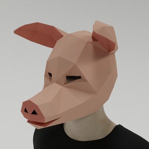 May include: A pink papercraft pig mask with a 3D design. The mask has a snout, ears, and eyes.