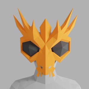 Puede incluir: Una máscara de papel naranja brillante, geométrica, con bordes afilados y puntiagudos y ojos negros. La máscara está diseñada para parecer un cráneo con una corona dentada y puntiaguda.