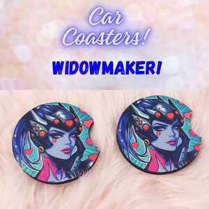 May include: Two round car coasters featuring a colorful illustration of Widowmaker from the video game Overwatch. The character is depicted with a pink and black outfit, a black helmet, and a blue background with hearts.