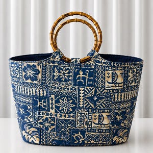 Peut inclure: Un sac fourre-tout avec un motif patchwork bleu et crème composé de divers éléments géométriques, floraux et marins. Le sac possède deux anses circulaires en bambou fixées sur le dessus, et l'intérieur est doublé d'un tissu bleu foncé uni.