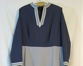 May include: A long-sleeved dress with a navy blue bodice and a white and navy blue gingham skirt. The bodice has a white trim around the neckline.