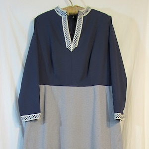 May include: A long-sleeved dress with a navy blue bodice and a white and navy blue gingham skirt. The bodice has a white trim around the neckline.