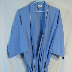 May include: A light blue robe with white trim and a matching belt. The robe is hanging on a blue hanger against a white background. The robe has short sleeves and two pockets.