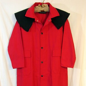 May include: A long red coat with a black collar. The coat has a button-up front and two pockets on the front.