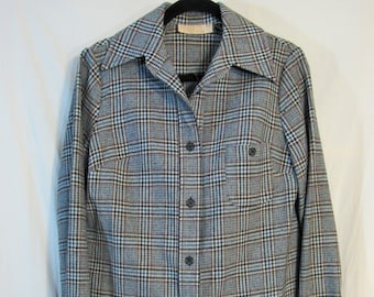 May include: A plaid pantsuit with a long-sleeved button-up shirt and matching pants. The fabric is a blue, red, and white plaid pattern.