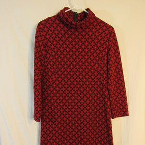 May include: A red and black geometric patterned dress with a mock neck and long sleeves.
