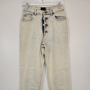 May include: Light blue acid wash denim jeans with a button fly and five pockets.