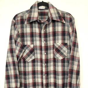 May include: A vintage plaid shirt in grey, black, and red. The button-down shirt features two front pockets and a wide collar. The label reads "My Shabby".