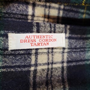 Pu&ograve; includere: Un tessuto con motivo tartan Dress Gordon nei toni del blu scuro, verde bosco, bianco e sottili linee gialle. Un'etichetta rettangolare bianca &egrave; cucita sul tessuto con il testo rosso AUTHENTIC DRESS GORDON TARTAN.