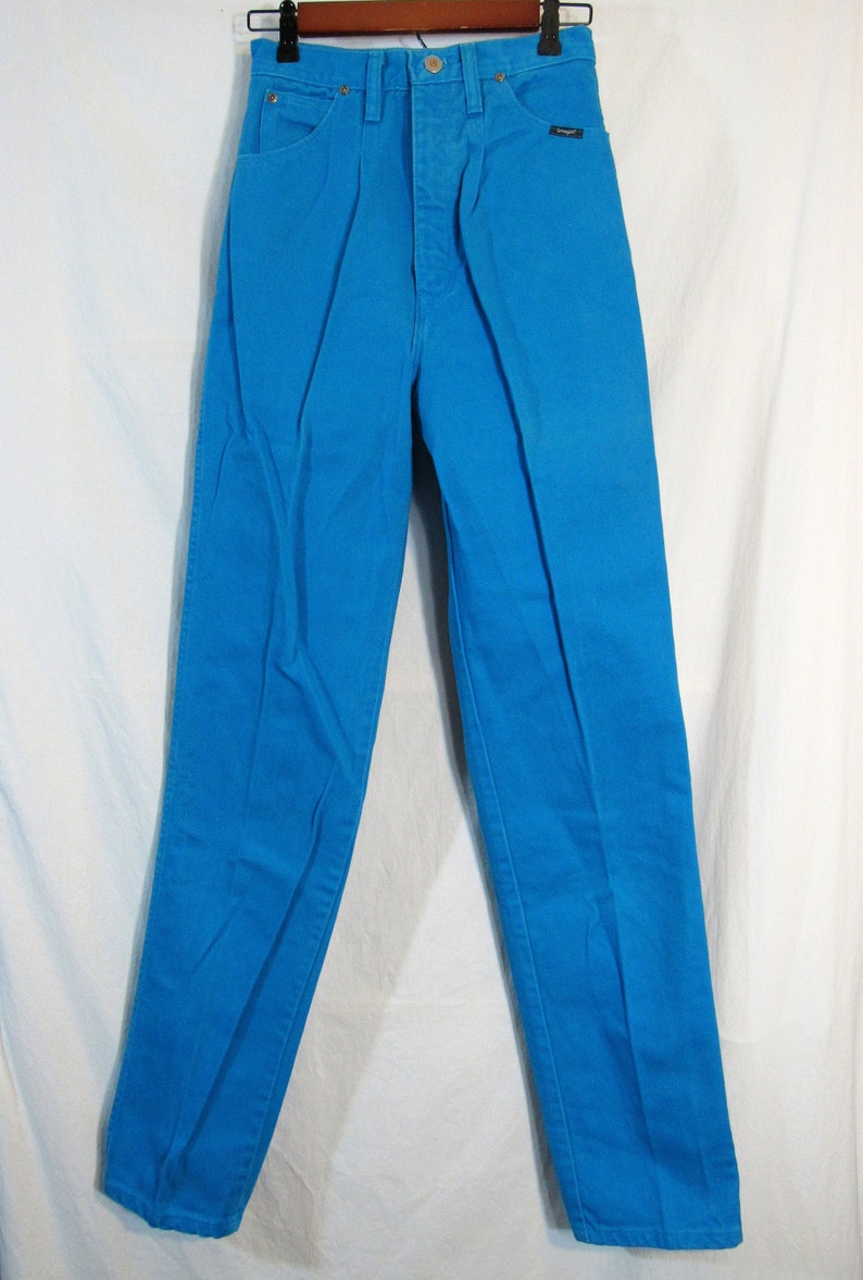 Puede incluir: Un par de pantalones vaqueros azules de cintura alta. Los vaqueros son de un color azul brillante, casi el&eacute;ctrico.