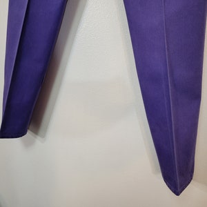 May include: A pair of purple pants with a classic, tailored design. The pants are a solid color and appear to be made of a durable fabric. The legs are straight and have a slight crease down the front.
