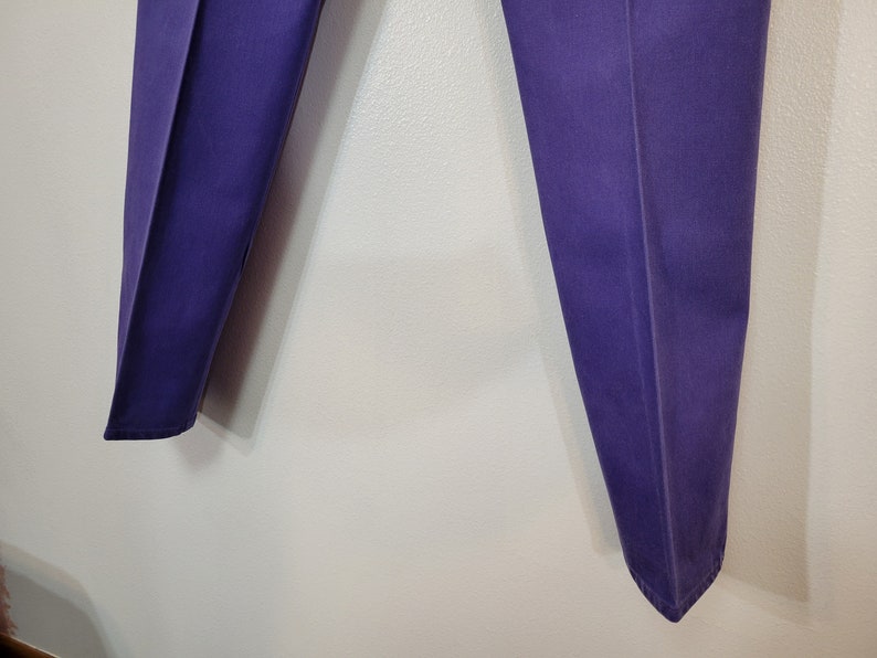 May include: A pair of purple pants with a classic, tailored design. The pants are a solid color and appear to be made of a durable fabric. The legs are straight and have a slight crease down the front.