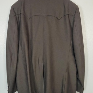 May include: A dark brown blazer with a subtle pinstripe pattern. The blazer has a single-breasted closure and a notched lapel.