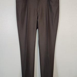 May include: A pair of brown pinstripe trousers with a straight leg fit. The trousers have a zip fly and button fastening.
