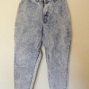 May include: Light blue acid wash denim jeans with a high waist and a straight leg.