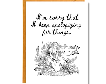 May include: A greeting card with a black and white illustration of a woman sitting in a field with birds flying overhead. The text on the card reads "I'm sorry that I keep apologizing for things."