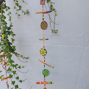 Mobile made of painted branches, branch slices and beads/wind chime/decoration to hang