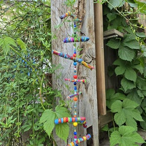 Mobile made of painted branches and beads/wind chimes