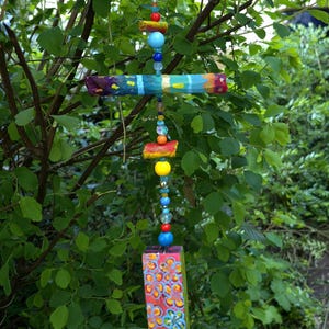 Hanging decoration made of painted pieces of wood, branches and beads/wind chime