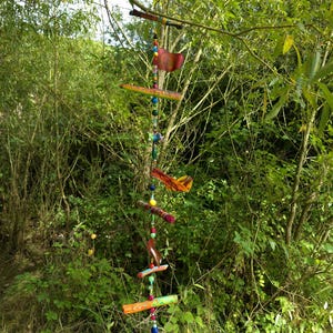 Mobile made of painted branches and shrink film in between beads/wind chime