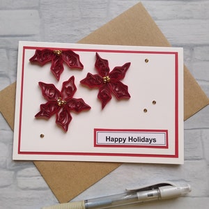 Tarjeta de felicitación navideña con flor de Pascua y arte de quilling de papel en 3D