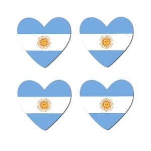 Può includere: Quattro adesivi a forma di cuore con il design della bandiera argentina. Ogni adesivo ha uno sfondo azzurro con una striscia orizzontale bianca al centro. Il centro della striscia bianca presenta un sole giallo con un volto.