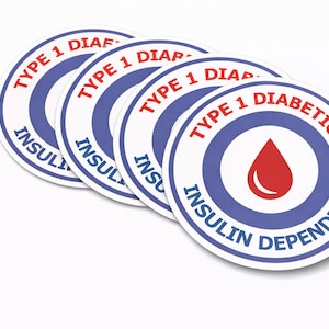 May include: Four white, circular stickers with blue and red text. The text reads "TYPE 1 DIABETIC" and "INSULIN DEPENDENT" around a red drop symbol. The stickers are slightly overlapping on a white background.