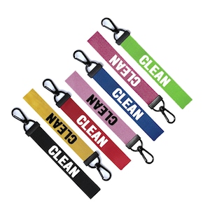 以下が含まれることがあります： 黒い金属製の留め具と、各ストラップに白で印刷された「CLEAN」という文字が付いた、6つのカラフルなキーホルダーです。