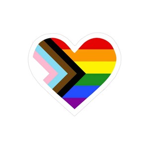 May include: A heart-shaped sticker with a rainbow flag design, including the colors red, orange, yellow, green, blue, indigo, and violet. The heart also features a black and brown chevron pattern, representing the progress pride flag.