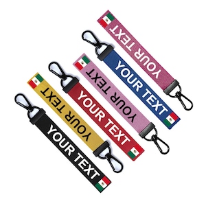 May include: Five colourful keychains with black metal rings and a small Mexican flag on each. The keychains are made of fabric and have the text "YOUR TEXT" printed on them in white.