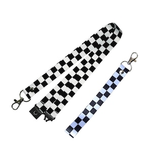 May include: Two black and white checkered lanyards with silver clips. One lanyard is longer than the other.