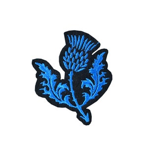 May include: Blue embroidered thistle patch with a black background.