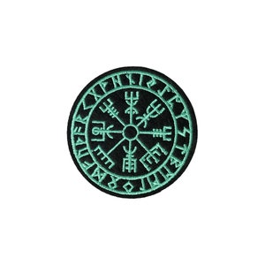 May include: Black and green embroidered patch with a compass design and runes around the edge.