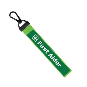 May include: Green and white lanyard with a black clip and the text "First Aider" and a white plus sign.