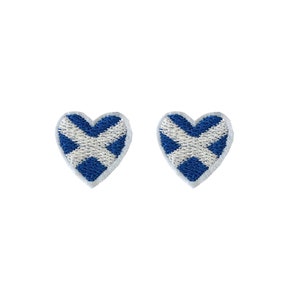 May include: Two heart-shaped patches. Each patch features the Scottish flag design: a white saltire on a blue field. The patches have a white border and are set against a white background.