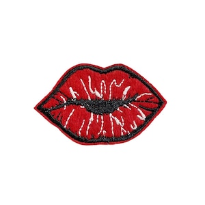May include: A red embroidered patch in the shape of a pair of lips. The lips are outlined in black with white highlights and a black center. The patch is likely for clothing or accessories.