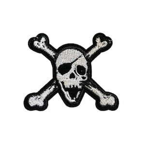 Op de afbeelding: Geborduurde patch met een schedel met een ooglapje en gekruiste botten. De schedel is wit met zwarte details, en de botten en rand zijn zwart. Geschikt voor kleding of accessoires.