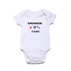 May include: White baby grow with the text "Engineer in Training" and a lightbulb, gear, and wrench graphic.